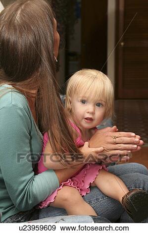 Stock Photo -  toddler mr looking at camera sitting in mothers. Fotosearch