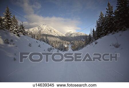 winter rocky mountains in road snow covered View Large Photo Image Stock Photography - winter rocky mountains in road snow covered. Fotosearch