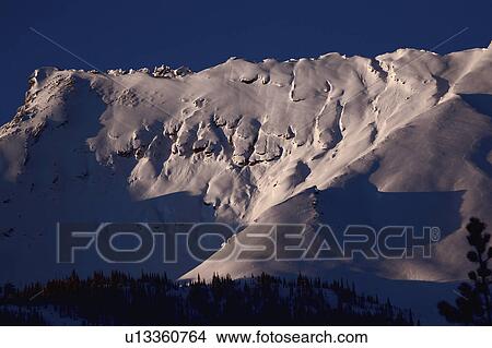 Picture -  winter rocky mountains in snow covered shadows. Fotosearch