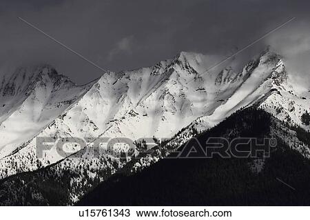 Stock Image -  winter rocky mountains in snow covered shadows. Fotosearch