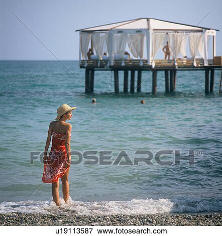 Stock Photo -  woman beach person 25-30 years brimmed hat cabana. Fotosearch
