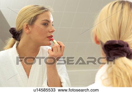Stock Image -  woman fashion applying lipstick mirror junge. Fotosearch
