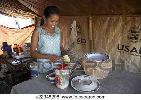 Stock Photo -  woman food people timor leste camp for displaced. Fotosearch