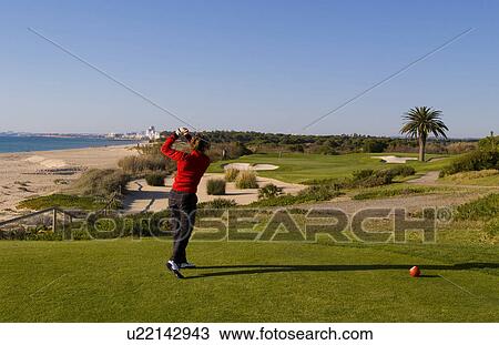 Stock Image -  woman golf golfing expensive ocean club in lago . Fotosearch