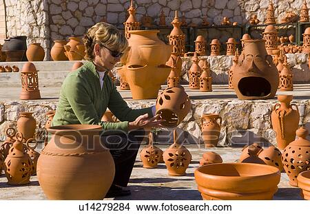 Picture -  woman shopping art tourist for pottery clay pots . Fotosearch