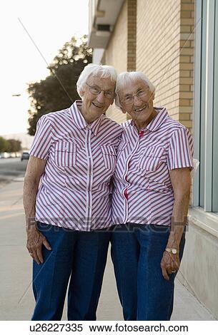 Stock Photography -  85 year old identical twins in matching dress. Fotosearch