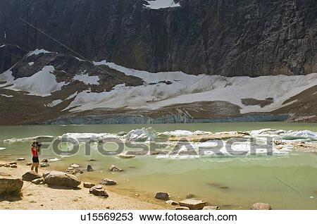 Stock Image -  angel female takes photograph berg lake foot. Fotosearch