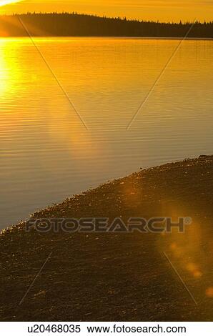 Stock Photography -  beach morning sunrise small alberta lake warming. Fotosearch