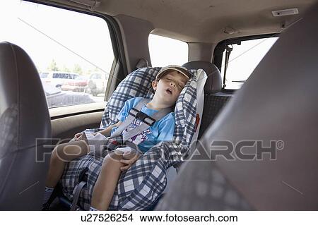 Picture -  car kid young boy in seat sleeps back carseat. Fotosearch