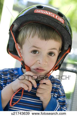child beauty cute young boy struggles put bike helmet View Large Photo Image Stock Photo - child beauty cute young boy struggles put bike helmet. Fotosearch