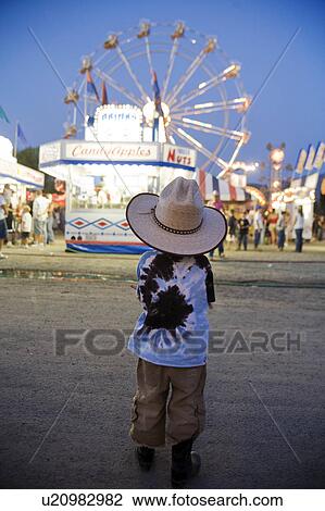 Stock Image -  child young boy looks ferris wheel fair rodeo . Fotosearch