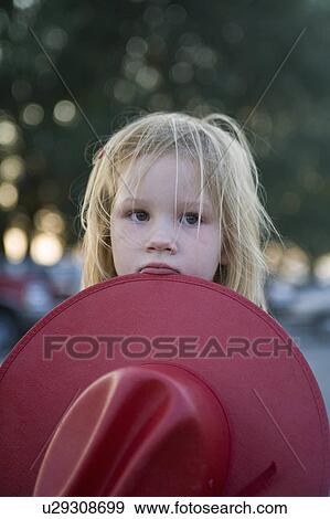 Stock Photo -  child young cowgirl large red coboy hat waits. Fotosearch