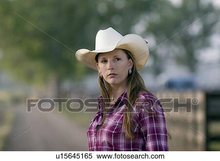 Stock Photography -  girl horse beauty serious cowgirl looks ranch . Fotosearch