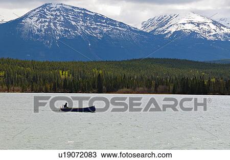Stock Image -  lone boater boating not so nice day choppy lake. Fotosearch