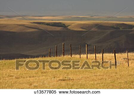 Stock Photography -  summer big muddy valley clouds fenceline pasture. Fotosearch