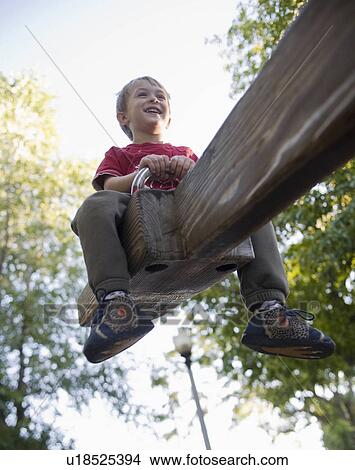 summer child young boy goes high see seesaw fun View Large Photo Image Picture - summer child young boy goes high see seesaw fun. Fotosearch
