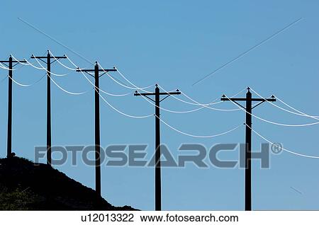 Stock Image -  sun backlit string power poles electric cables. Fotosearch
