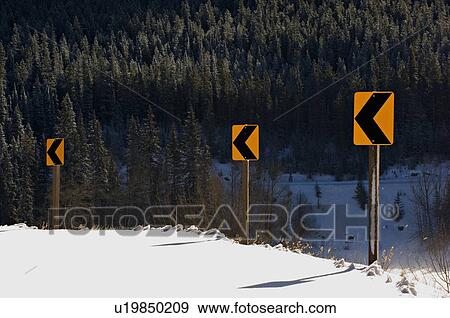 Stock Photo -  winter highway signs sharp bend rural mountain. Fotosearch