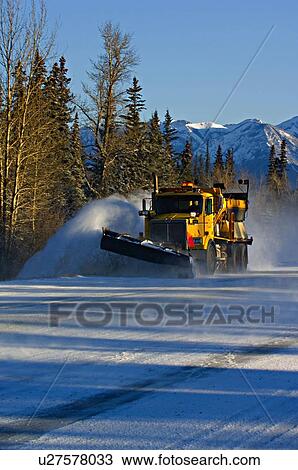 Stock Image -  winter vertical image truck plowing snow surface. Fotosearch