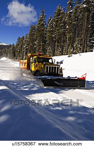 Stock Photo -  winter vertical image yellow snowplow truck snow. Fotosearch