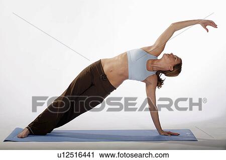 Stock Image -  woman beautiful sexy young practices yoga mat. Fotosearch