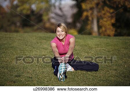 Stock Photograph -  woman fitness spring yoga works out in park pond. Fotosearch