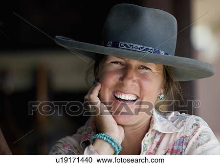 Stock Image -  woman horse cowgirl relaxes ranch in colorado. Fotosearch