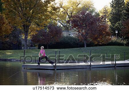 Stock Image -  woman spring yoga works out in park pond day. Fotosearch