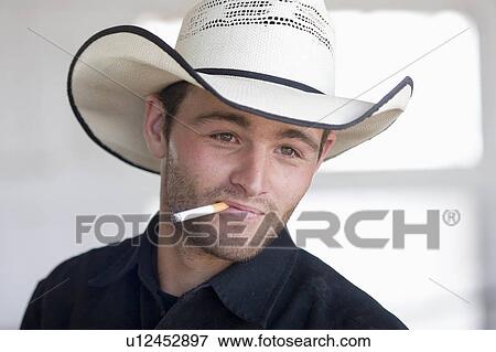 Stock Photo -  working cowboy ranch in colorado hat smoking. Fotosearch