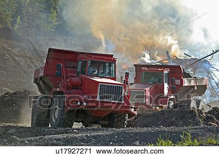 Stock Image -  construction fire two offroad rock trucks moving. Fotosearch