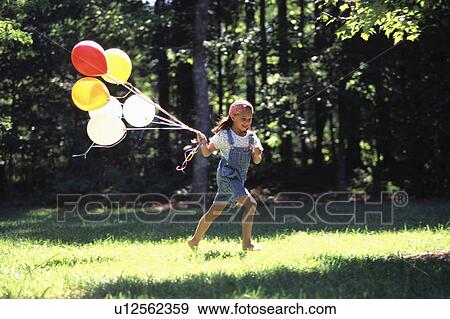 Stock Photo -  girl child kid running balloons brunette day. Fotosearch