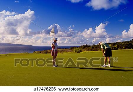 Stock Photograph -  golf couple putting ocean hole playing . Fotosearch