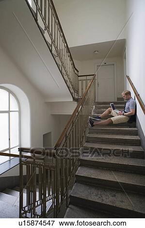 Stock Photo -  man laptop junger mann mit im young staircase. Fotosearch