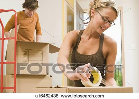 Stock Photo -  people house couple home moving packing day 20s. Fotosearch