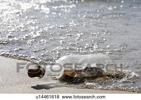 Stock Photo -  beach water generic message in bottle theme help. Fotosearch