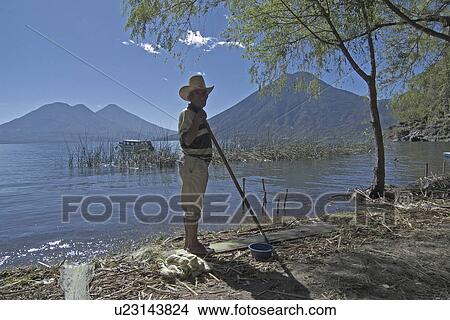 Picture -  beach water man guatemala cleaning garbage san . Fotosearch