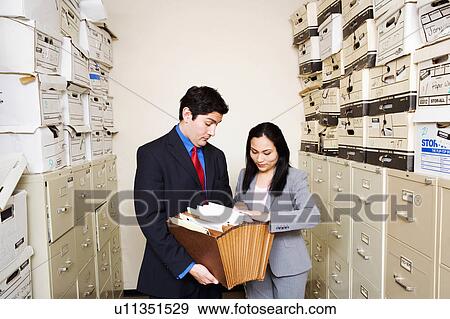 Stock Photo -  business searching for files 25-29 years 30-34. Fotosearch