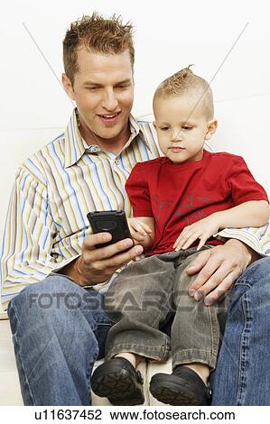 Stock Image -  child man mid adult playing video game son 30-34. Fotosearch