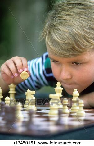 Stock Image -  child person boy playing chess 7-9 years blond. Fotosearch
