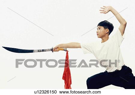 Stock Image -  child sport boy practicing martial arts sword. Fotosearch