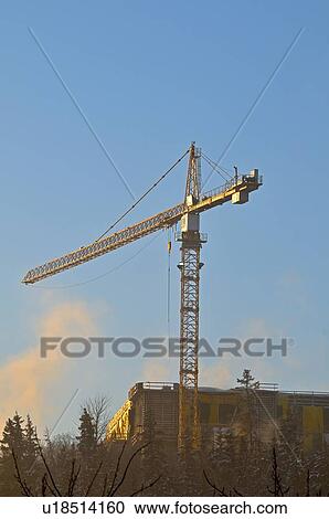 Stock Image -  construction large tower crane lifting building. Fotosearch