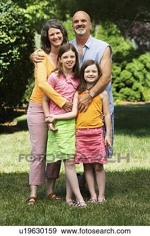 Stock Photo -  couple child mature standing two daughters 10-11. Fotosearch
