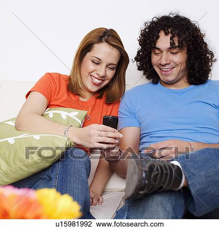 couple young sitting couch looking mobile phone View Large Photo Image Stock Image - couple young sitting couch looking mobile phone. Fotosearch