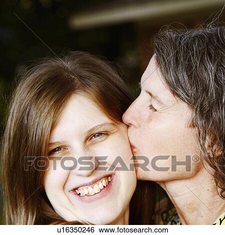 Stock Photograph -  family woman child closeup mature kissing 25-29. Fotosearch