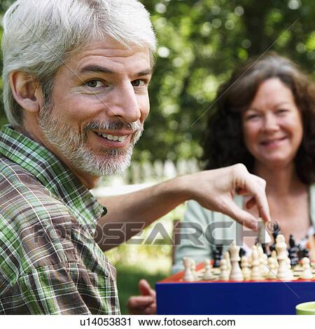 Stock Image -  food couple mature playing chess smiling 45-49 years. Fotosearch
