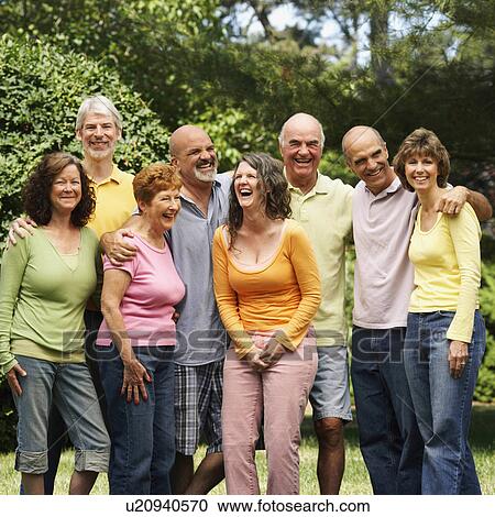 Stock Image -  friends standing in park smiling 45-49 years. Fotosearch