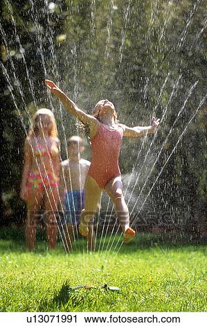 Stock Image -  girl child children jumping through lawn 5-6 suit. Fotosearch