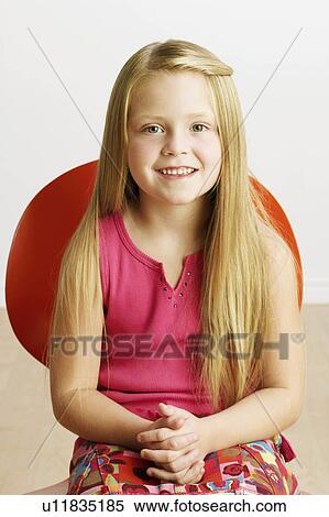 Stock Photography -  girl child closeup sitting chair smiling 6-7 hair. Fotosearch
