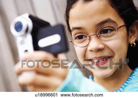 Stock Image -  girl child home closeup filming video camera 8-9. Fotosearch
