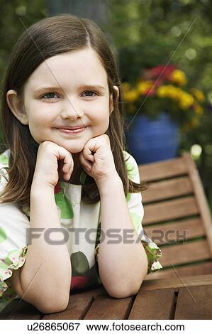 Stock Photo -  girl child leaning elbows smiling 8-9 years. Fotosearch